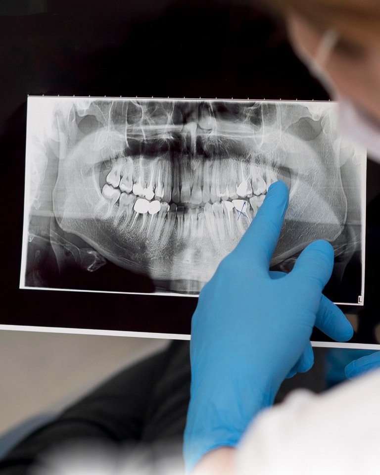 Odontóloga de Dental Safe explicando una radiografía dental a un paciente en el consultorio de Shopping Pinedo